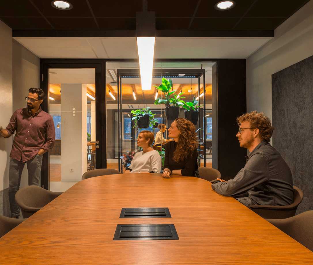 Medewerkers wonen een presentatie bij